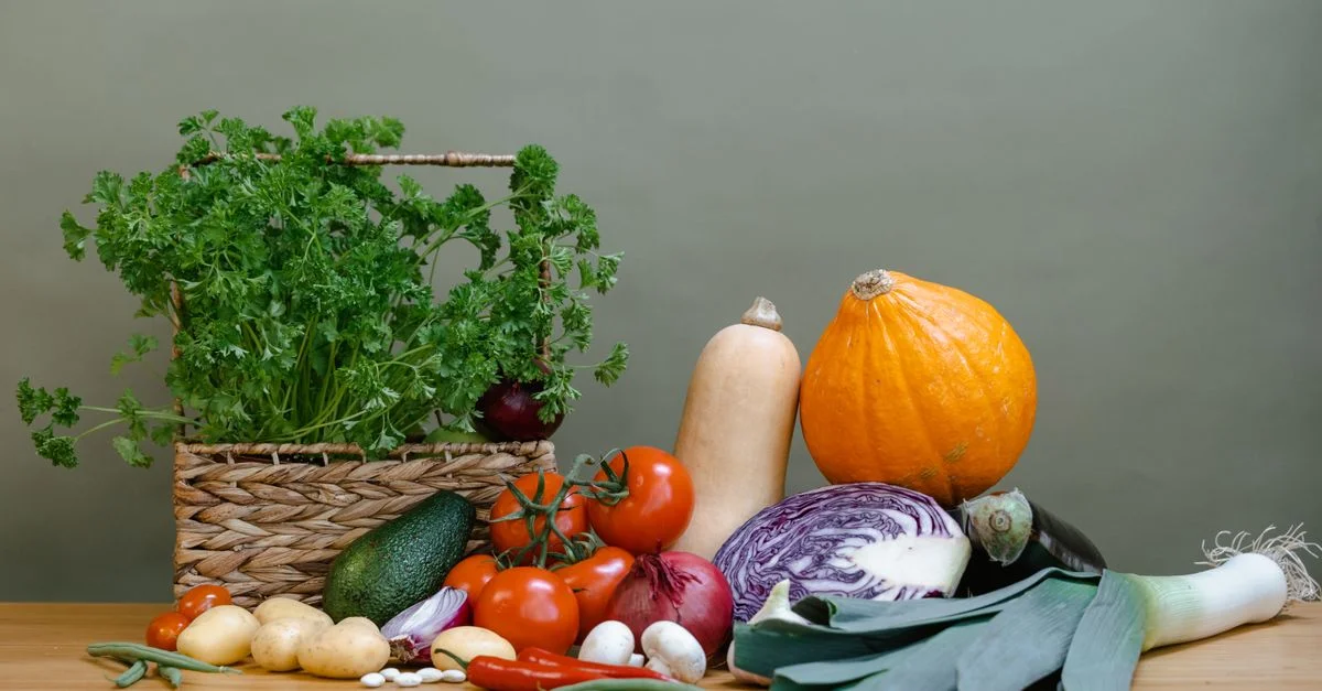 Un affichage vibrant de légumes frais, y compris des tomates, des courges et du persil.